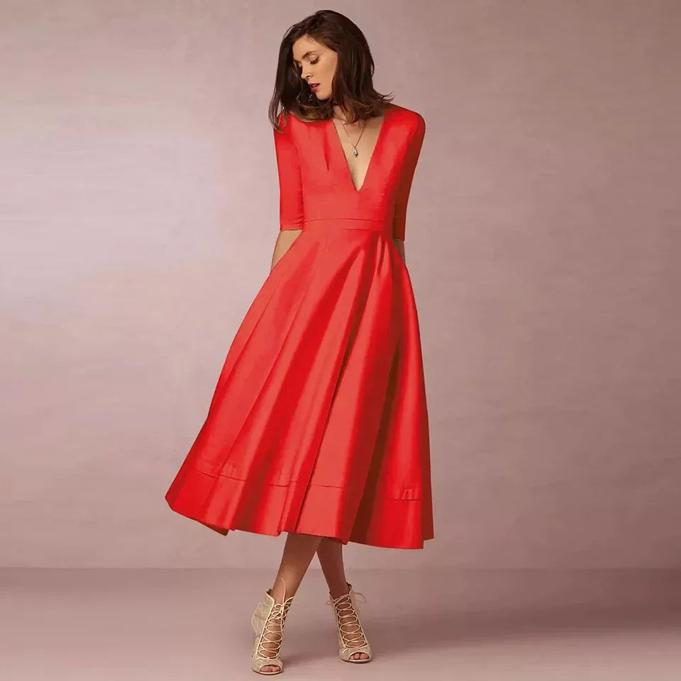 Frau in elegantem, rotem Kleid mit V-Ausschnitt und halblangen Ärmeln, posiert vor neutralem Hintergrund. Mode, Abendkleid, Damenbekleidung.