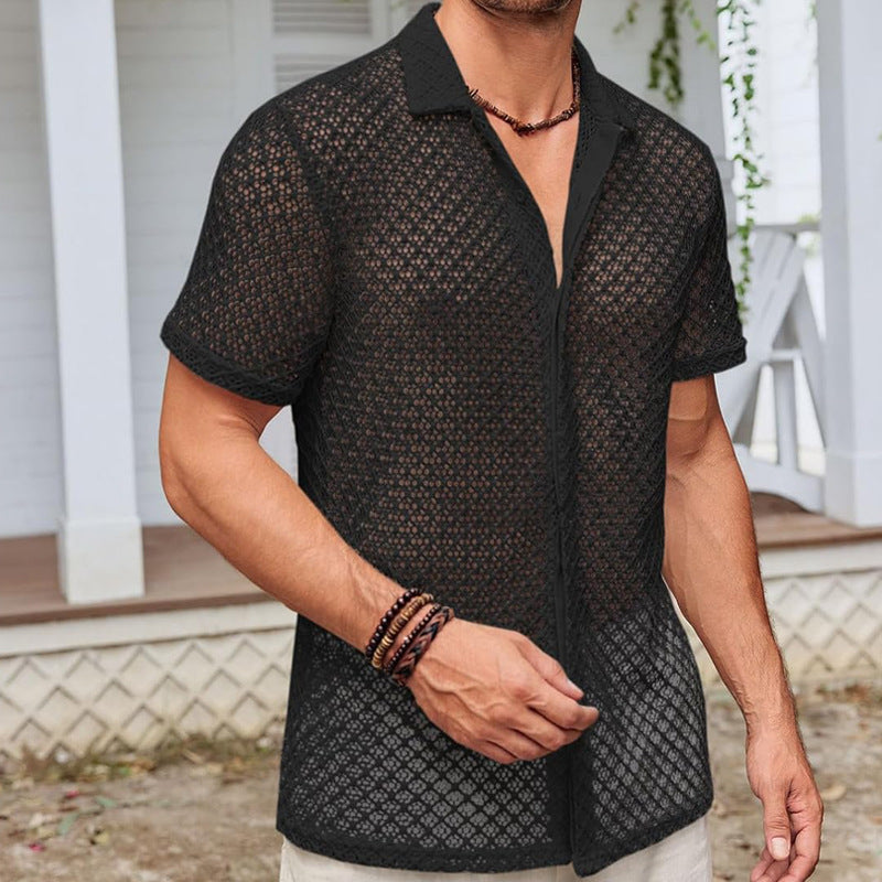 Mann trägt schwarzes Netzhemd vor weißem Haus. Sommermode, Herrenbekleidung, lässiger Stil, trendiges Outfit, modisches Design.