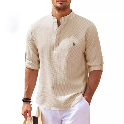 Beiger Herren-Henley mit Stehkragen, langen Ärmeln und dezenter Logo-Stickerei. Perfekt für lässige Sommermode und stilvolle Freizeitoutfits.