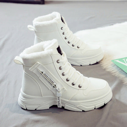 Weiße Damen-Winterstiefel mit Kunstfellfutter, seitlichem Reißverschluss und Schnürung auf grauem Hintergrund. Modische, warme Winterschuhe.