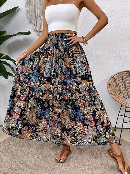Frau in weißem Top und langem, buntem Boho-Rock mit Paisley-Muster, steht auf Terrasse. Sommermode, Boho-Chic, Damenbekleidung.