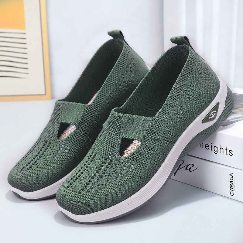Grüne Damen-Sneaker mit Strickmuster, rutschfeste Sohle, atmungsaktiv, ideal für Freizeit und Sport. Bequeme, modische Schuhe auf Bücher gestapelt.