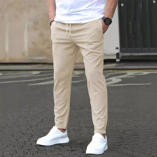 Beige Chinohose für Herren, kombiniert mit weißen Sneakers und weißem T-Shirt. Modischer Streetwear-Look, ideal für lässige Anlässe.