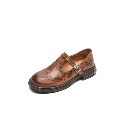 Brauner Lederschuh mit Schnalle, Brogue-Details und runder Spitze. Eleganter Damenschuh, ideal für Business- und Freizeitoutfits.