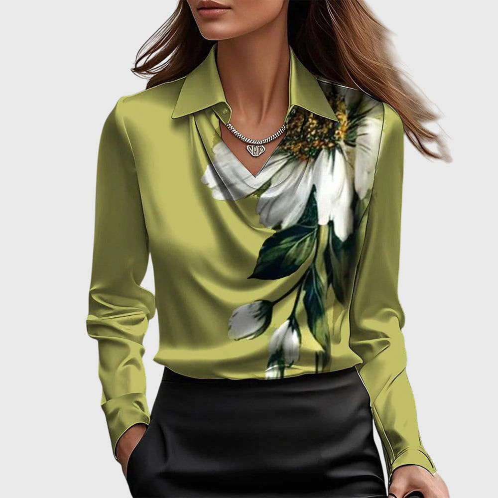 Frau in olivgrüner Bluse mit großem Blumenmuster, kombiniert mit schwarzem Rock. Elegante Mode, stilvolles Outfit, florales Design.