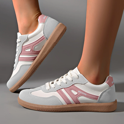 Weiße und rosa Damen-Sneaker mit brauner Sohle, seitlich fotografiert. Modische Sportschuhe, ideal für Freizeit und Sport.