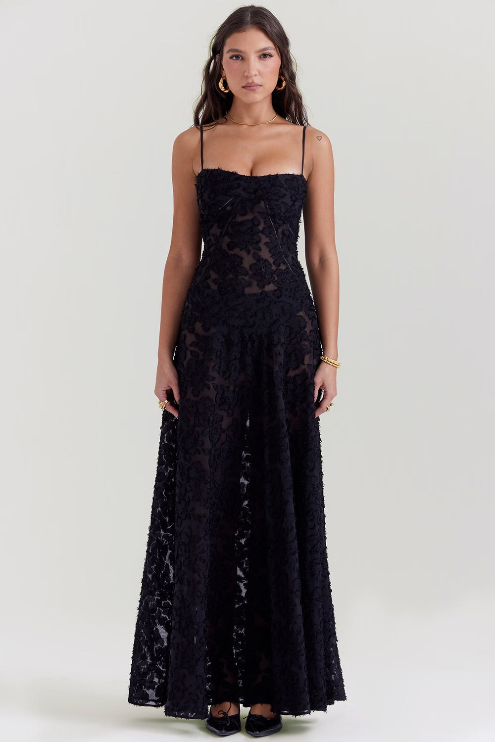Frau in elegantem, schwarzem Spitzenkleid mit Spaghettiträgern, bodenlang. Perfekt für Abendmode, formelle Anlässe, stilvoller Look.
