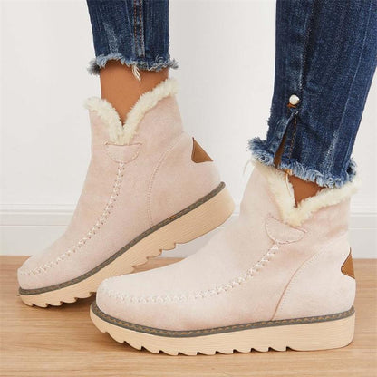 Damen Winterstiefel aus rosa Wildleder mit Kunstfellfutter, seitlichem Reißverschluss und genoppter Sohle, kombiniert mit blauen Jeans.