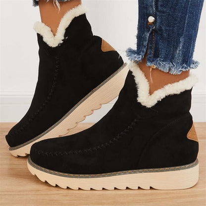 Schwarze Damen-Winterstiefel mit weißem Kunstfellfutter, dicker Sohle und Jeans kombiniert. Modische, warme Stiefel für kalte Tage.
