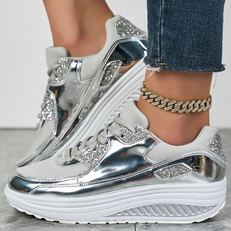 Silberne Plateau-Sneaker mit Glitzerakzenten, getragen mit blauer Jeans und goldener Gliederkette. Modische Damenschuhe, trendiger Look.