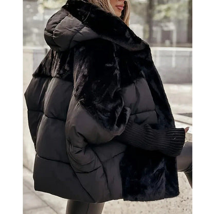 Frau in schwarzer Daunenjacke mit Kunstfellkapuze, modisch und warm, Wintermode, Outdoor-Bekleidung, stilvoller Look, urbane Kulisse.