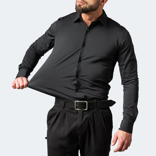 Mann in schwarzem, elastischem Hemd zieht am Stoff, um Flexibilität zu demonstrieren. Modische Herrenbekleidung, dehnbares Material, elegantes Design.