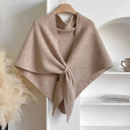 Beigefarbener Wollschal auf Kleiderbügel, elegant drapiert, vor weißem Hintergrund. Perfekt für Herbstmode, Damenaccessoires, stilvoller Look.