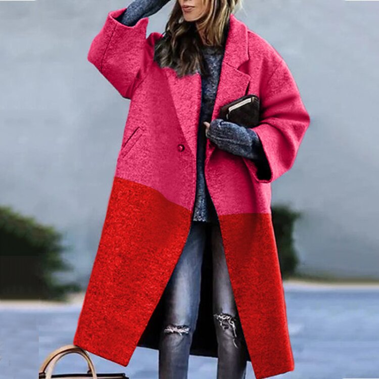 Frau in modischem, zweifarbigem Mantel in Pink und Rot, kombiniert mit Jeans und grauem Pullover. Trendige Wintermode, stilvoller Look.