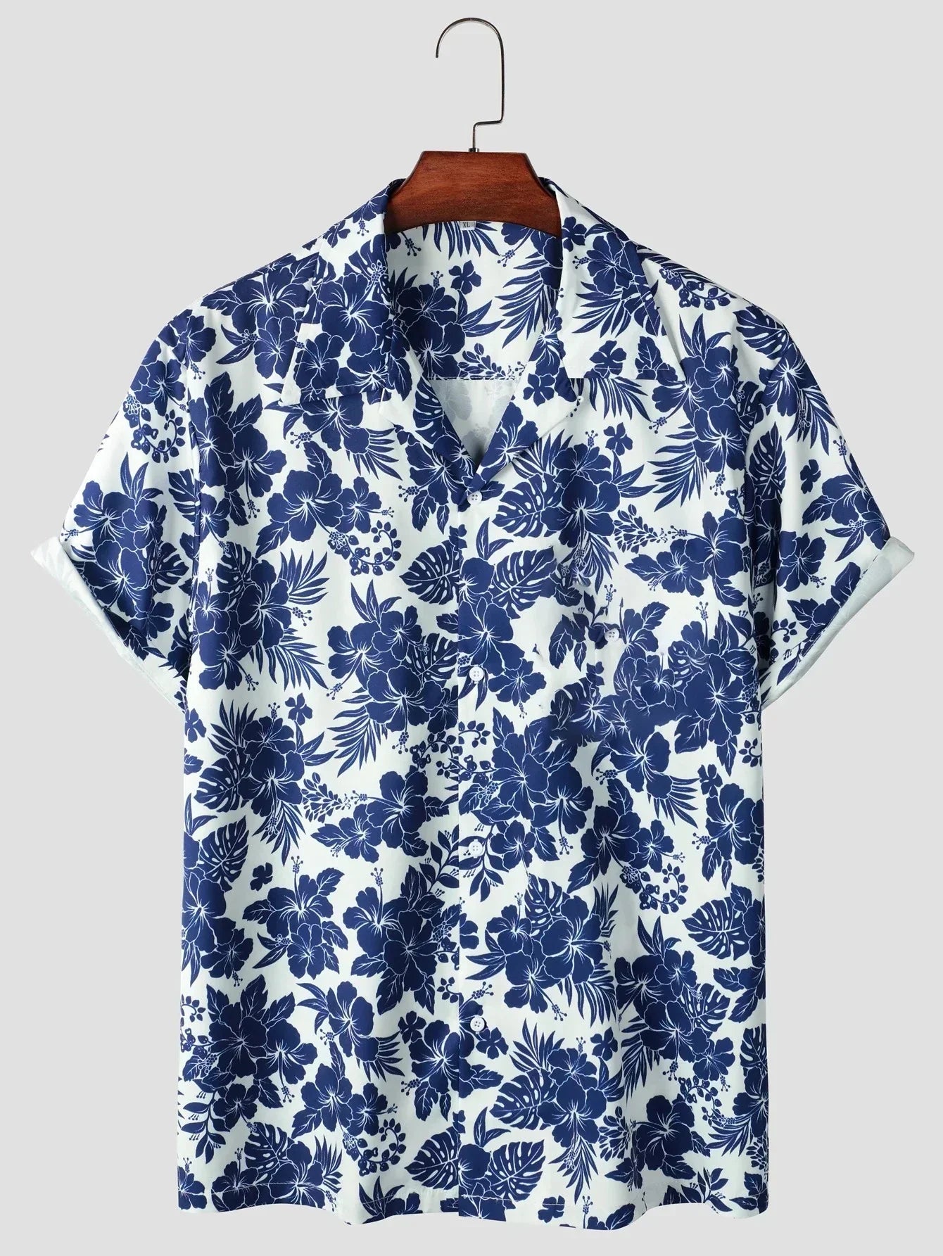 Kurzarm-Hemd mit blau-weißem Blumenmuster, tropisches Design, lässiger Stil, ideal für Sommermode, Herrenbekleidung, auf Holzkleiderbügel.
